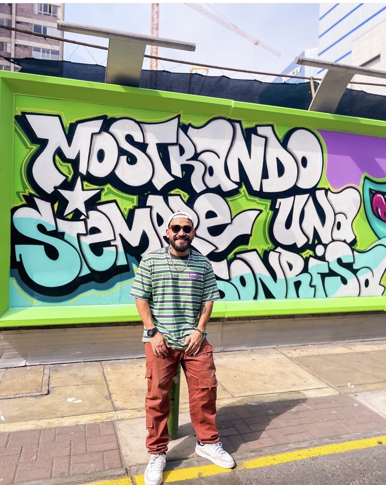 Yetro in front of a colorful graffiti wall